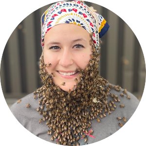 caucasian woman wearing a bandana over her hair, with hundreds of honey bees crawling up her neck on an her face 